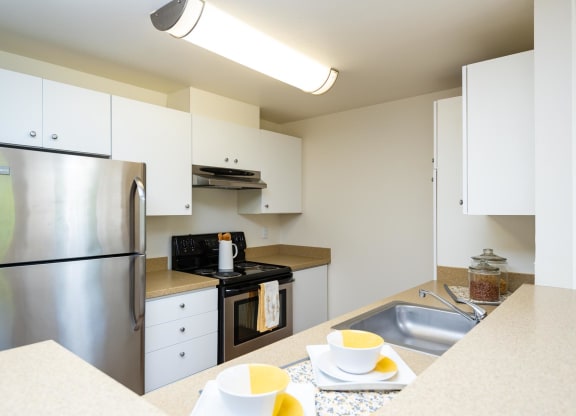 a kitchen with stainless steel appliances and white cabinets at Murrayhill Park, Oregon, 97008