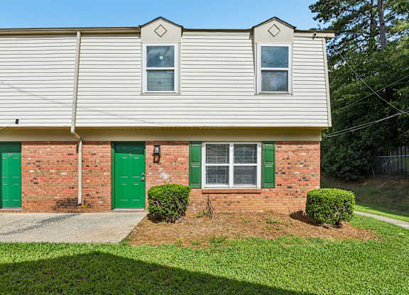 A house with a green door and a grey roof.