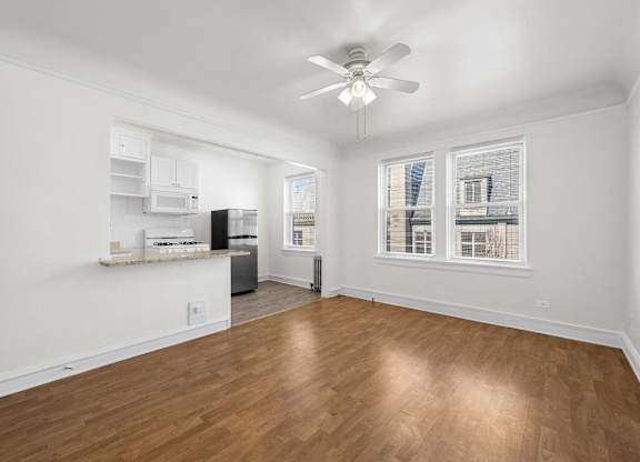 A room with a ceiling fan and wooden flooring at Pleasant Oak Apartments, Oak Park, IL