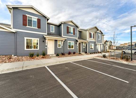 A parking lot in front of a row of houses.