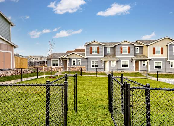 A row of houses with a black fence in front.