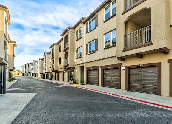 A row of apartment buildings with garages on the side.