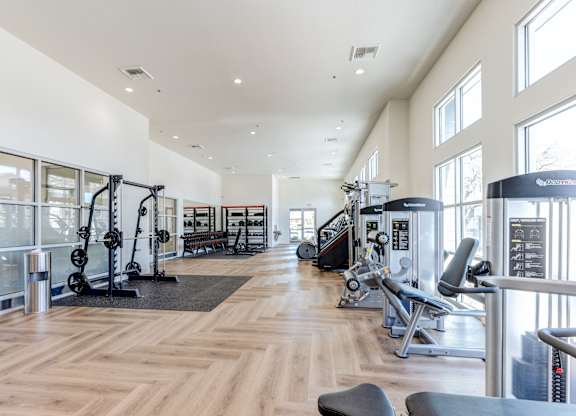 A gym with a variety of equipment including weights and cardio machines.