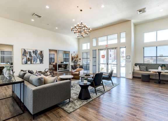 A spacious living room with a grey sofa and a wooden floor.