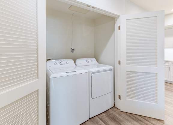 A white washing machine and dryer in a small laundry room.