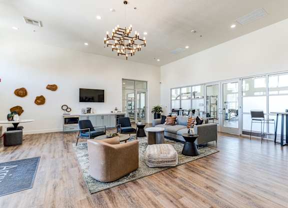 A modern living room with a wooden floor and a large chandelier.