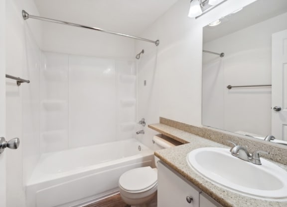 bathroom with white tub shower, toilet, and sink at Murrayhill Park, Beaverton Oregon