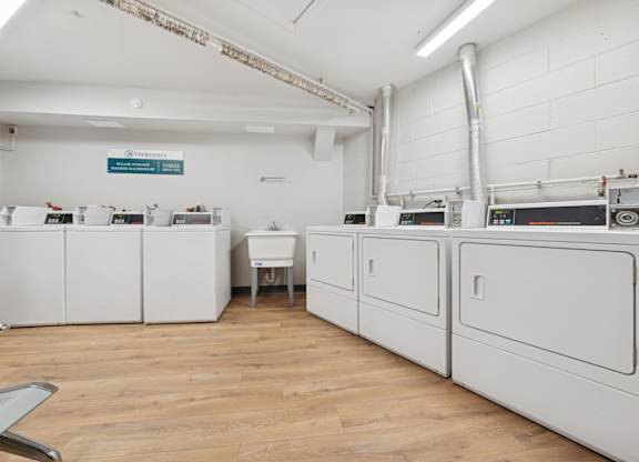 A room with white cabinets and a wooden floor.