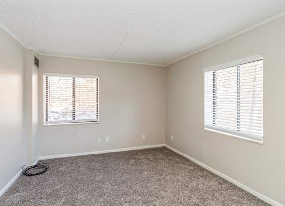 A room with a window and a hose on the floor.