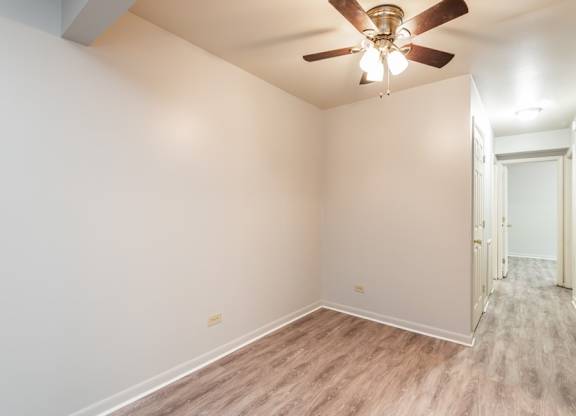 A room with a ceiling fan and light fixture.