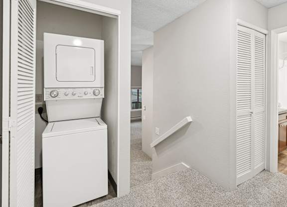 A white washing machine and dryer in a laundry room.