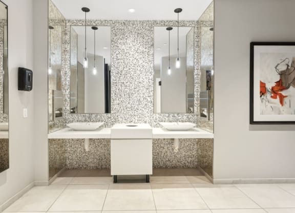 a bathroom with two sinks and three mirrors