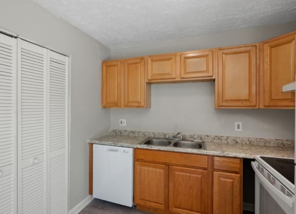 a kitchen with wooden cabinets and a white dishwasherat Fort Collier Terrace, Winchester, 22601