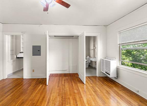 A room with a wooden floor and a ceiling fan.