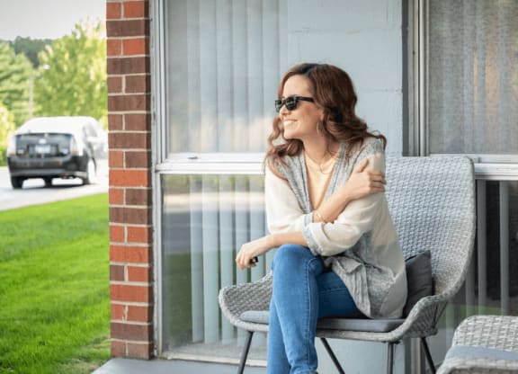a woman sitting on a chair on a porch at St. Charles, St. Charles, IL, 60174