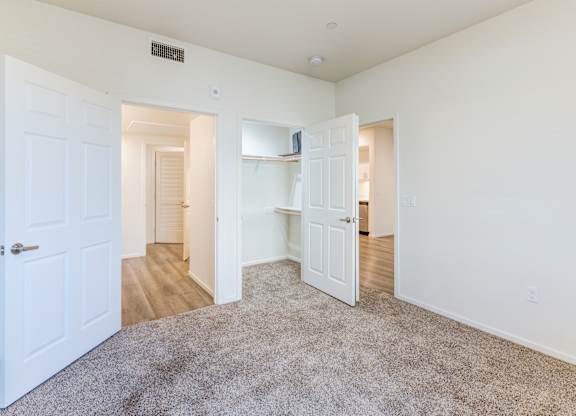 A room with white walls and a grey carpet.