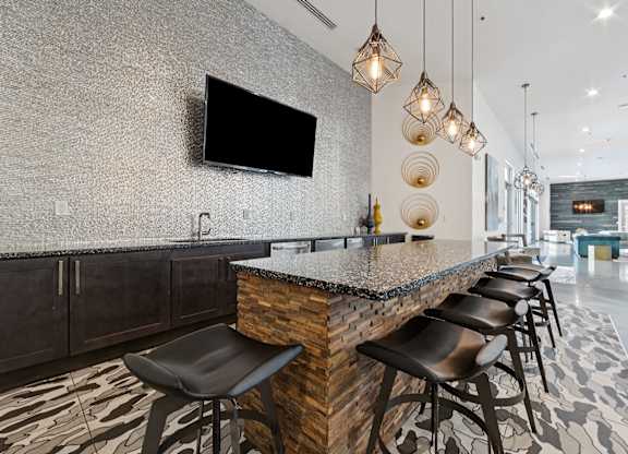 A modern table with a stone counter and black stools.