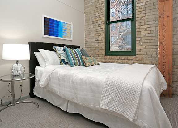 Bedroom with a bed and nightstand at FreightYard Townhomes and Flats, Minneapolis, 55401