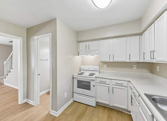A kitchen with white cabinets and appliances.