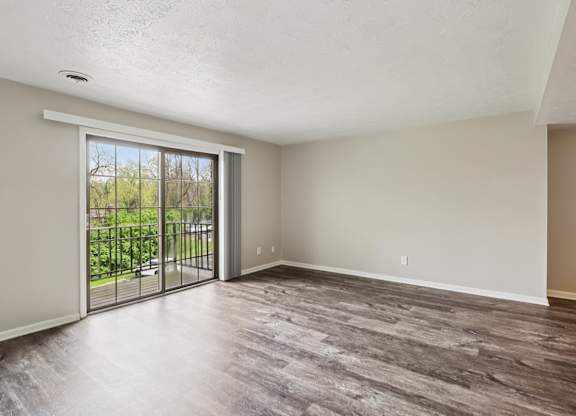 A room with a sliding glass door leading to a balcony.