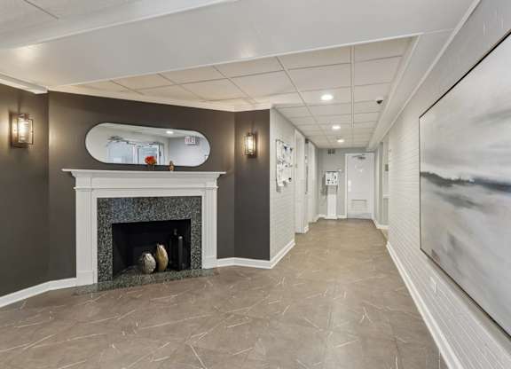 A long hallway with a fireplace and a painting on the wall.