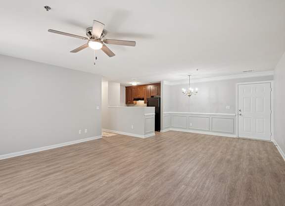 A room with a ceiling fan and wooden flooring.