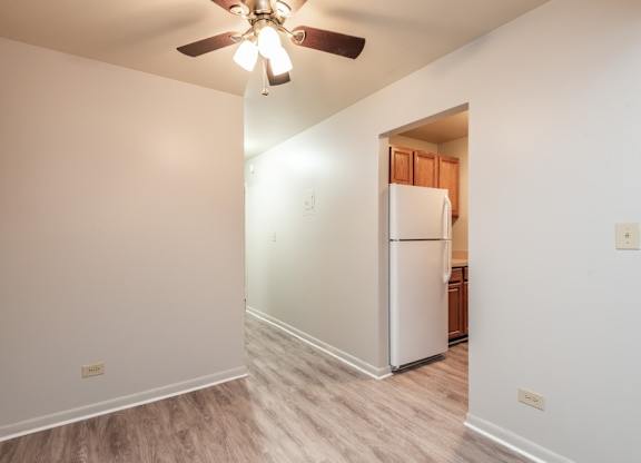 A white refrigerator in a kitchen with a ceiling fan.