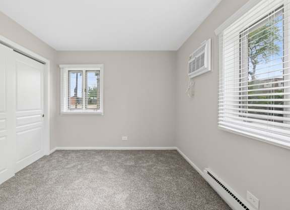 A bedroom with a window and a door.