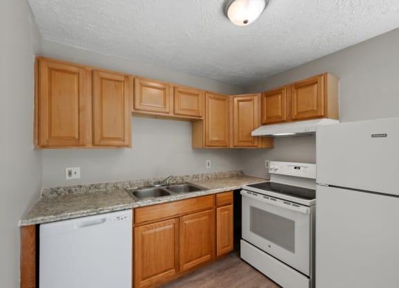 a kitchen with wood cabinets and white appliances at Fort Collier Terrace, Winchester Virginia