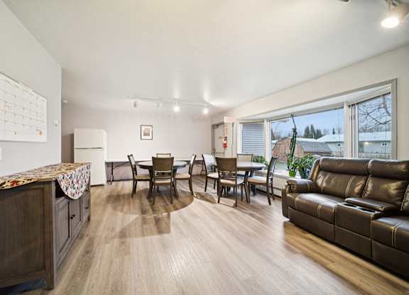 A living room with a brown leather couch and a wooden cabinet.