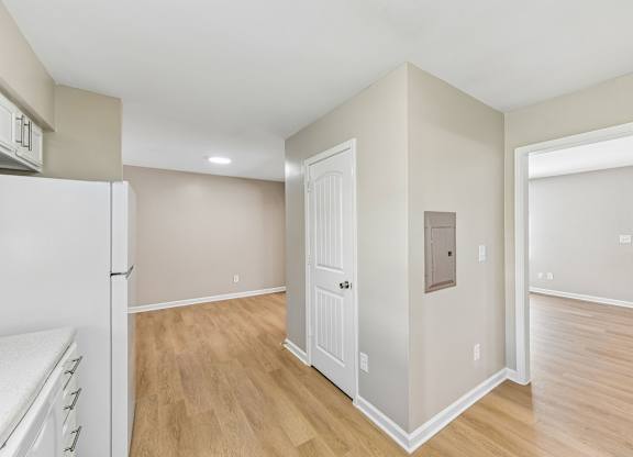 A kitchen with a white refrigerator and wooden floors.