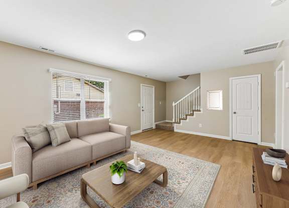 A living room with a couch, a coffee table, and a rug.