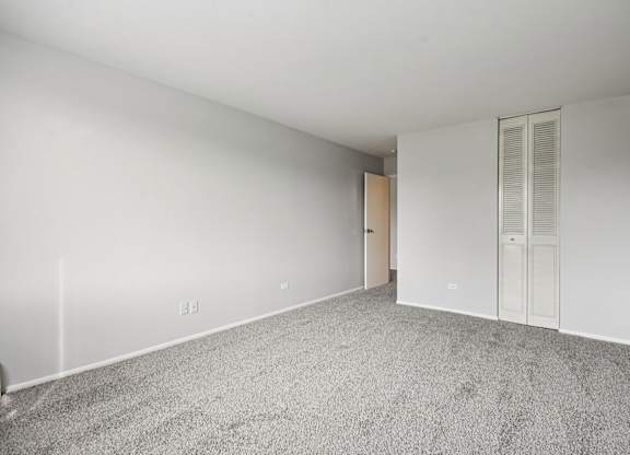 A room with a carpeted floor and white walls.