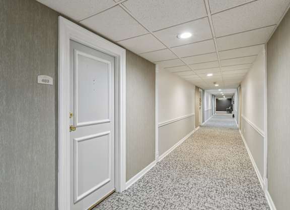 A long hallway with a door on the left and a door on the right.