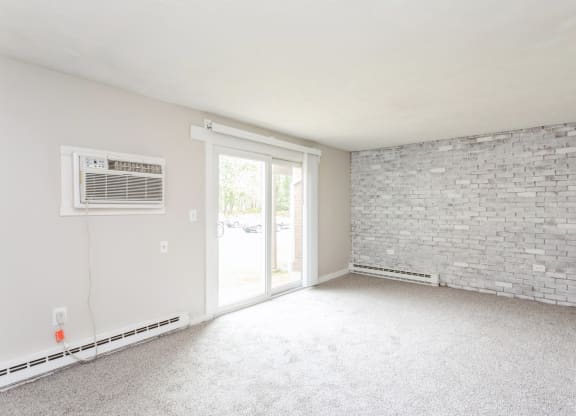 an empty living room with a brick wall and a glass sliding door at Stonebridge, Ellington