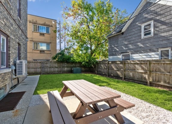 the backyard with a picnic table and a privacy fence