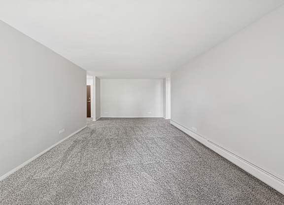 A long hallway with a carpeted floor and white walls.
