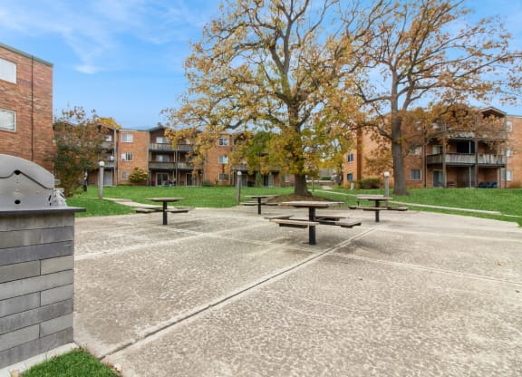 an empty park with benches in front of a building at River Oaks, Illinois