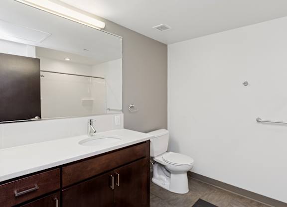 A white sink is in a bathroom with a toilet and a shower.