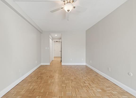 A room with a wooden floor and a ceiling fan.