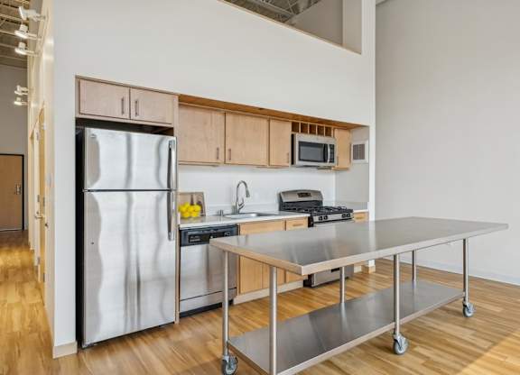 A kitchen with a refrigerator, stove, and microwave.