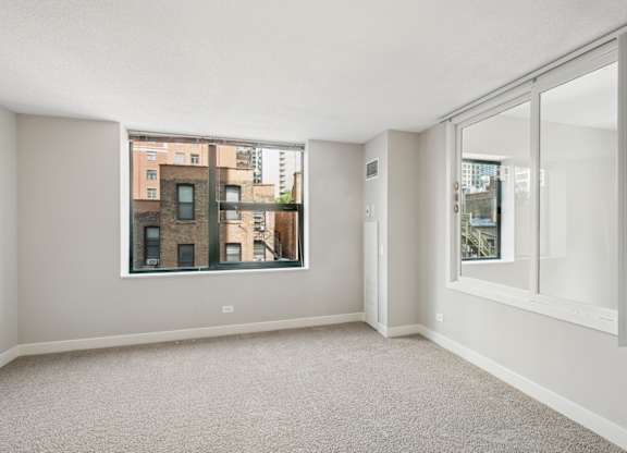 A large, empty room with a view of a cityscape through a window.