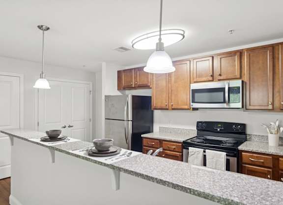 A kitchen with wooden cabinets and a black refrigerator.