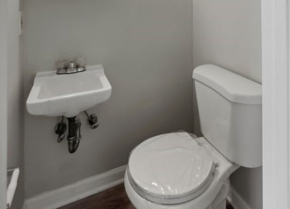 a bathroom with a toilet sink and mirror at Fort Collier Terrace, Virginia