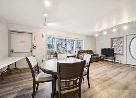 A dining room with a table and chairs.