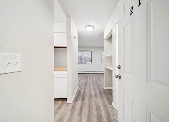 A hallway with a white door on the right and a number 2 on the door.