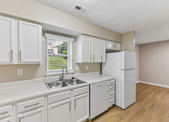 A kitchen with white cabinets and appliances.