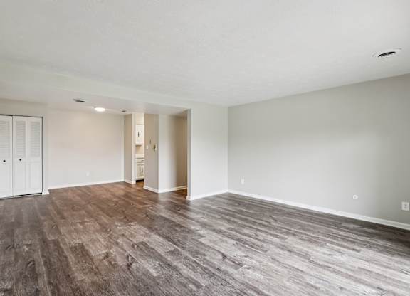 A room with wooden flooring and white walls.