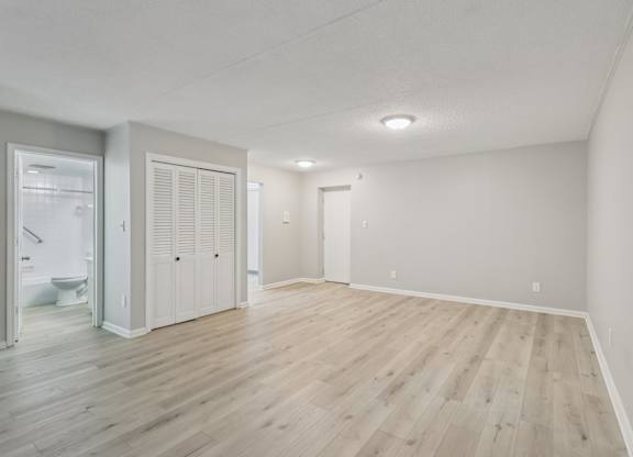 A room with wooden flooring and white walls.