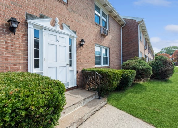 the front of a brick apartment with a white door